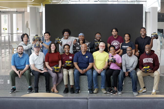 Around two dozen participants from the Summer Robotics Session sit for a group photo.