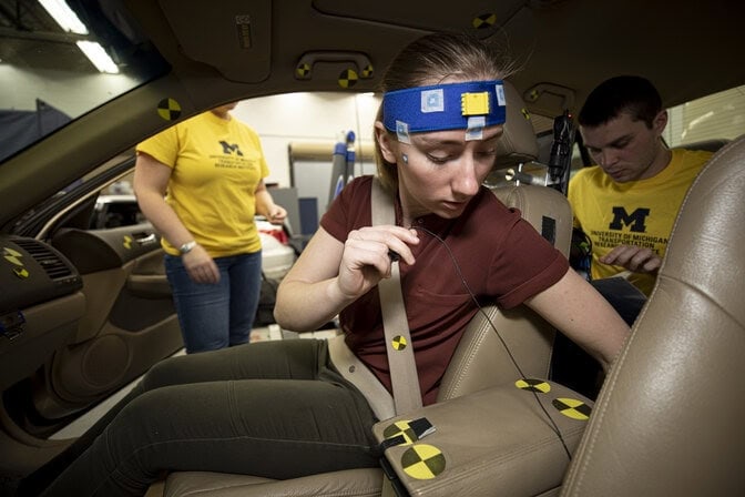 researchers adjusting equipment inside a vehicle